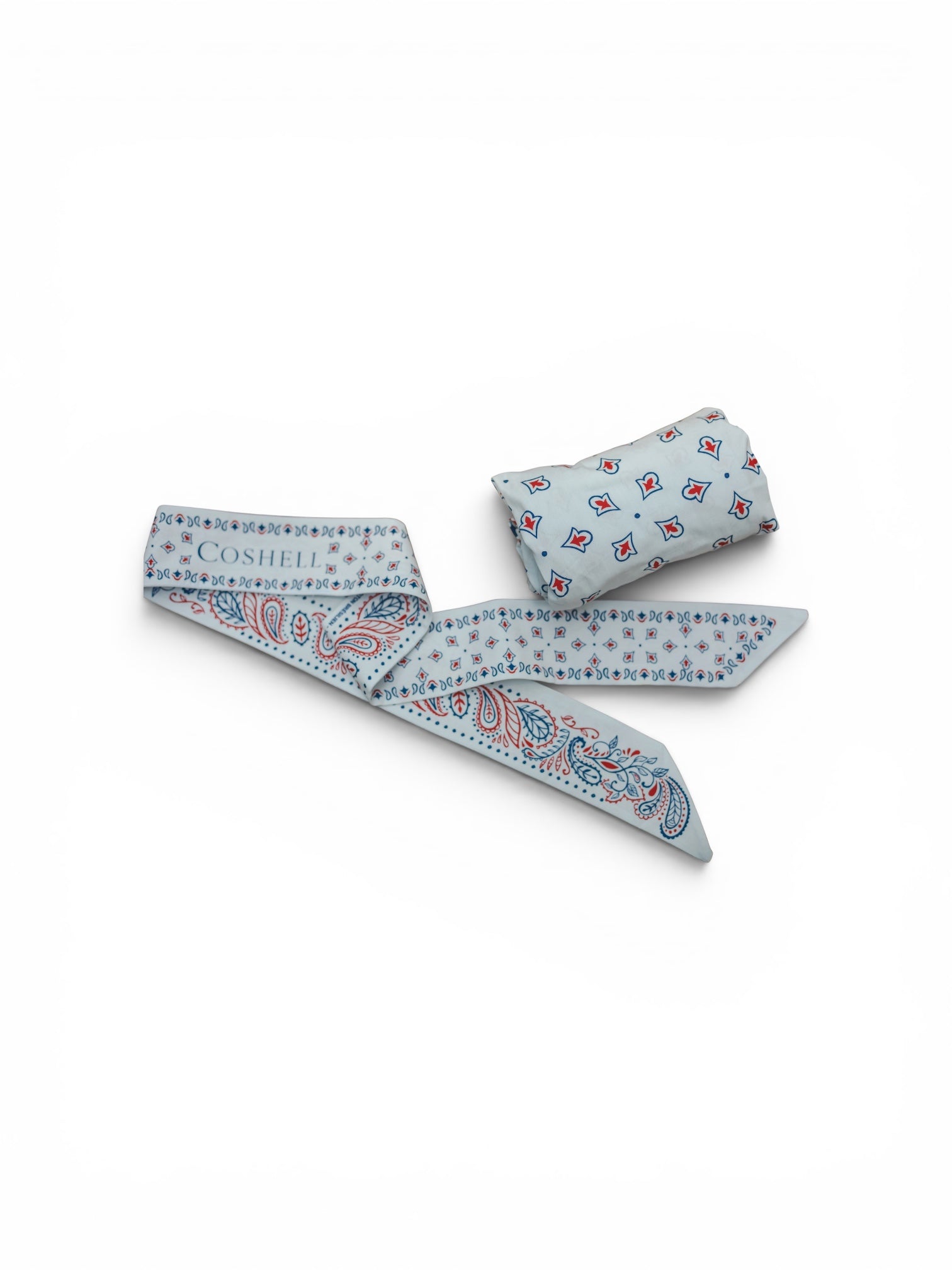 A white cotton twilly scarf with a red and blue paisley pattern, featuring the brand name 'Coshell' printed on one end, displayed next to its matching rolled body bandana sarong on a white background.