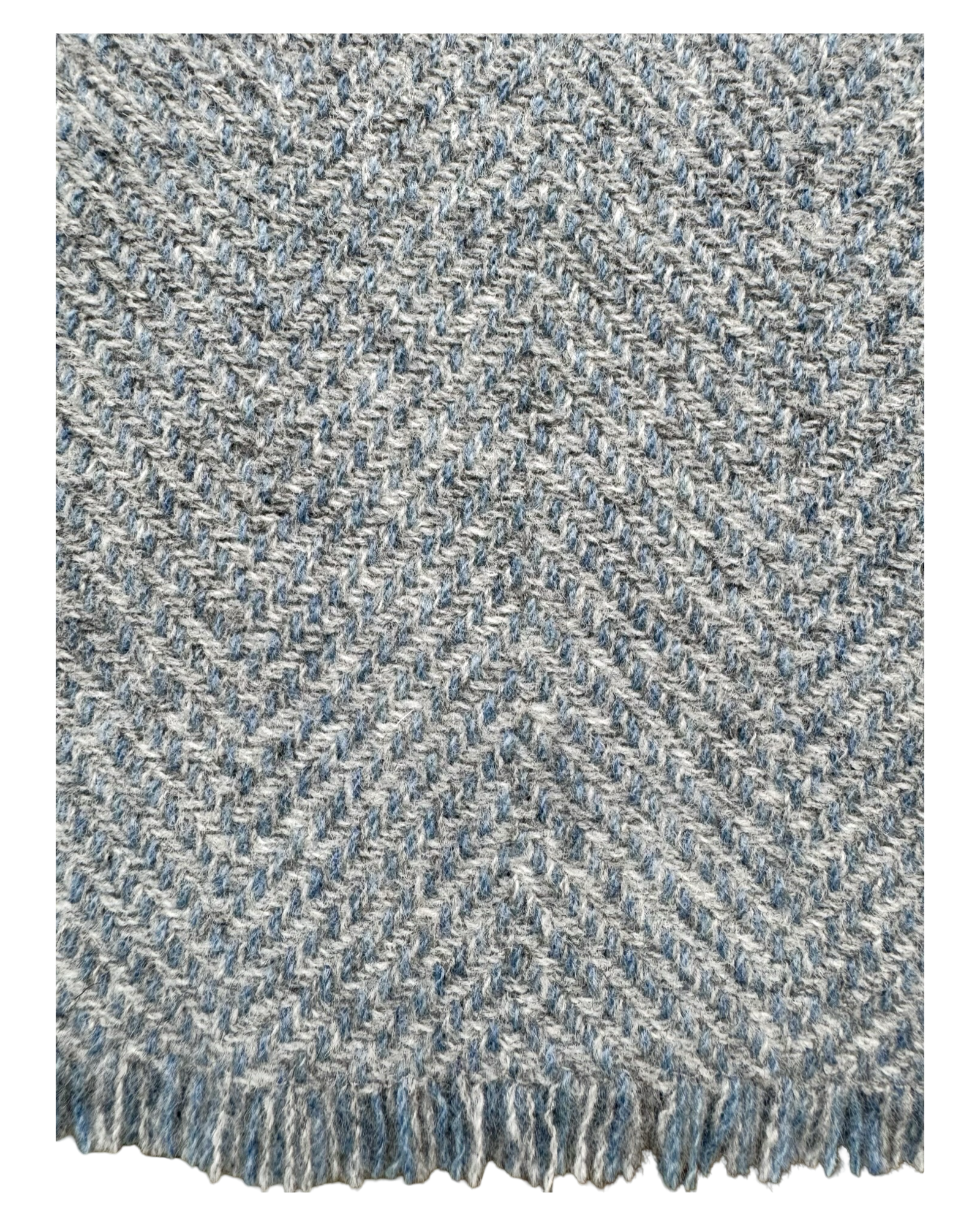 A close-up of woven wool textile with a herringbone pattern in heathered blue, gray, and off-white, finished with a short fringe along the bottom edge.
