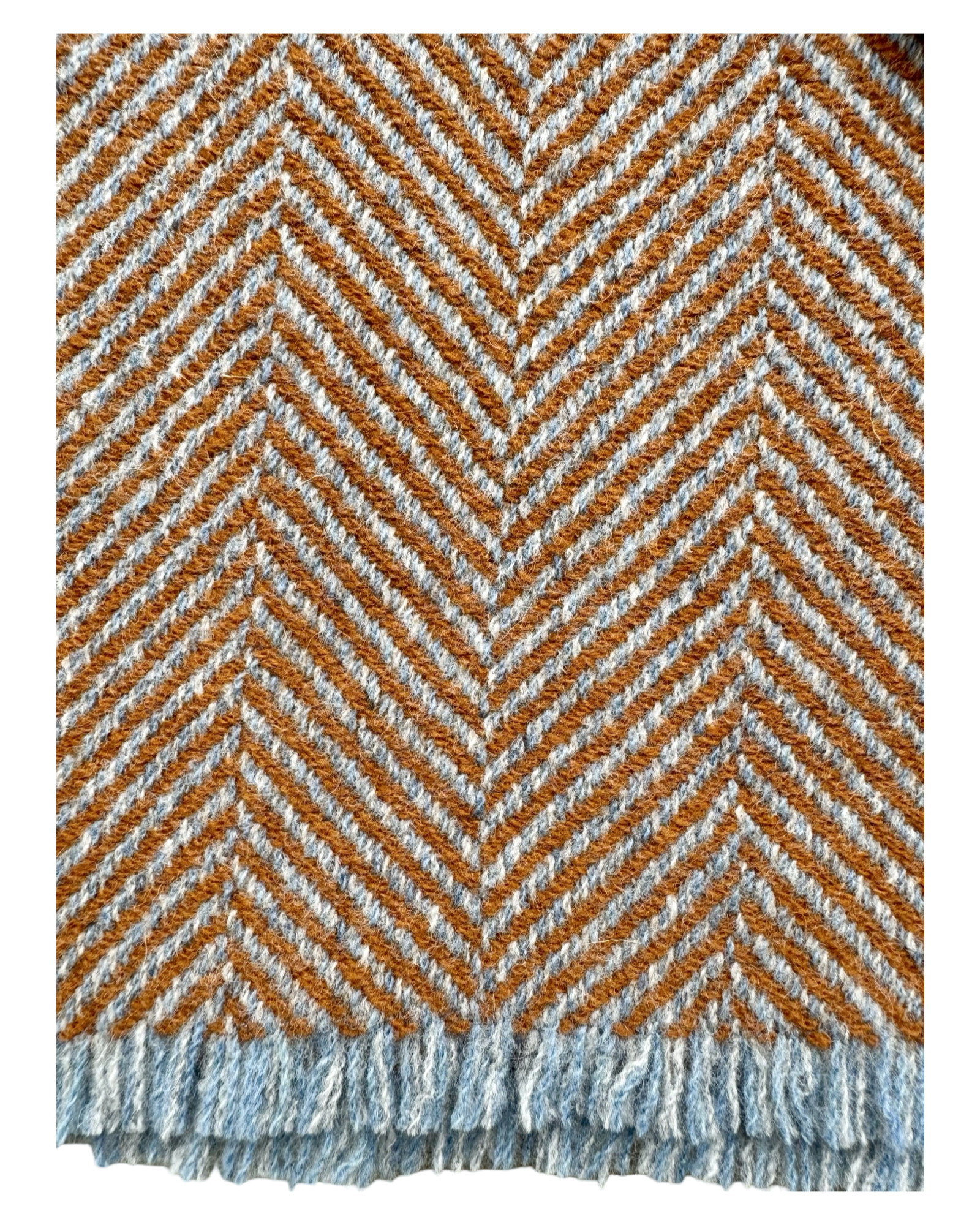 A close-up of woven wool textile with a herringbone pattern in rust orange,cream land ight blue, finished with a fringed edge.