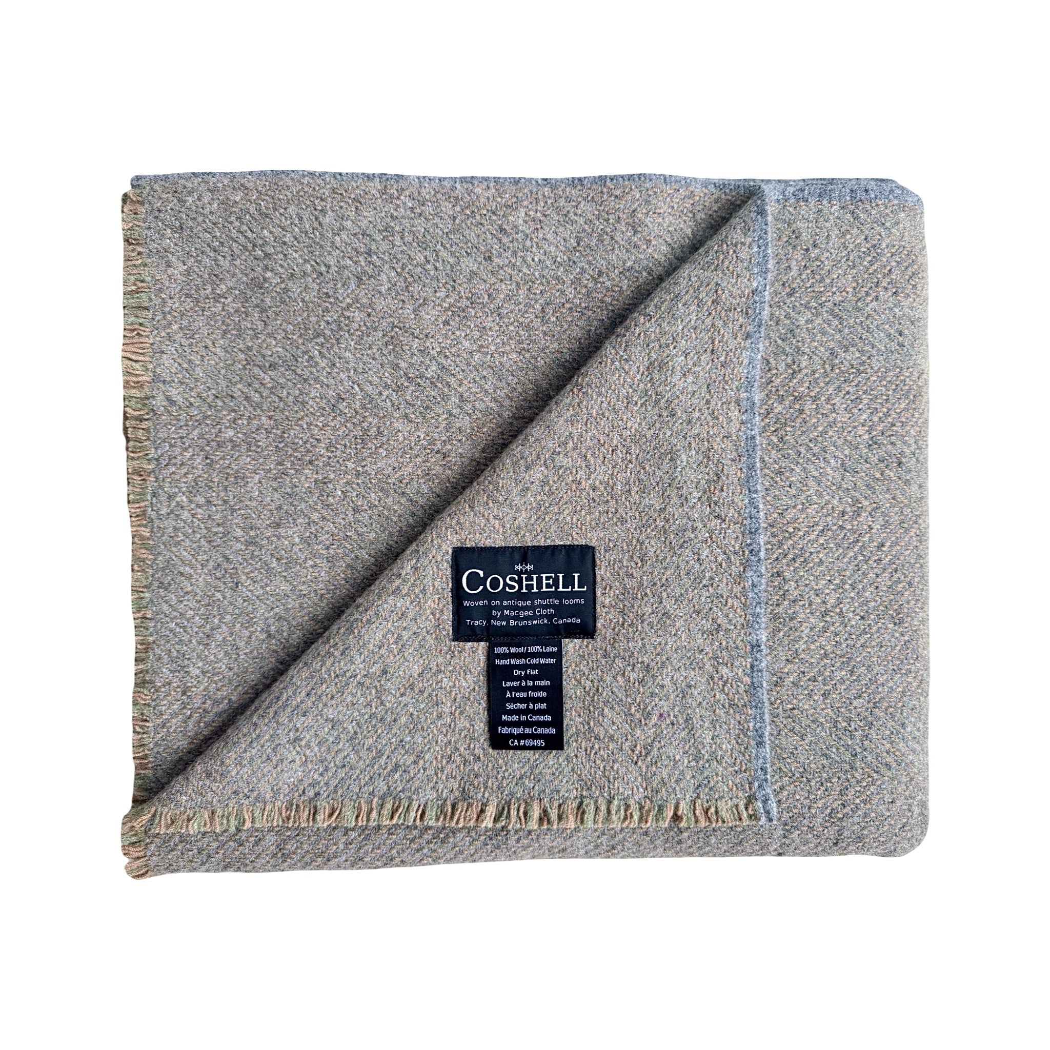 A folded Coshell wool blanket in a heathered blue orange and green herringbone pattern, featuring a black brand label in the center and fringed edges